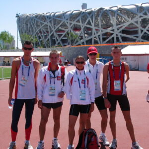 Nasi uczniowie reprezentują Polskę na olimpiadzie w Chinach. Polska grupa na tle stadionu.