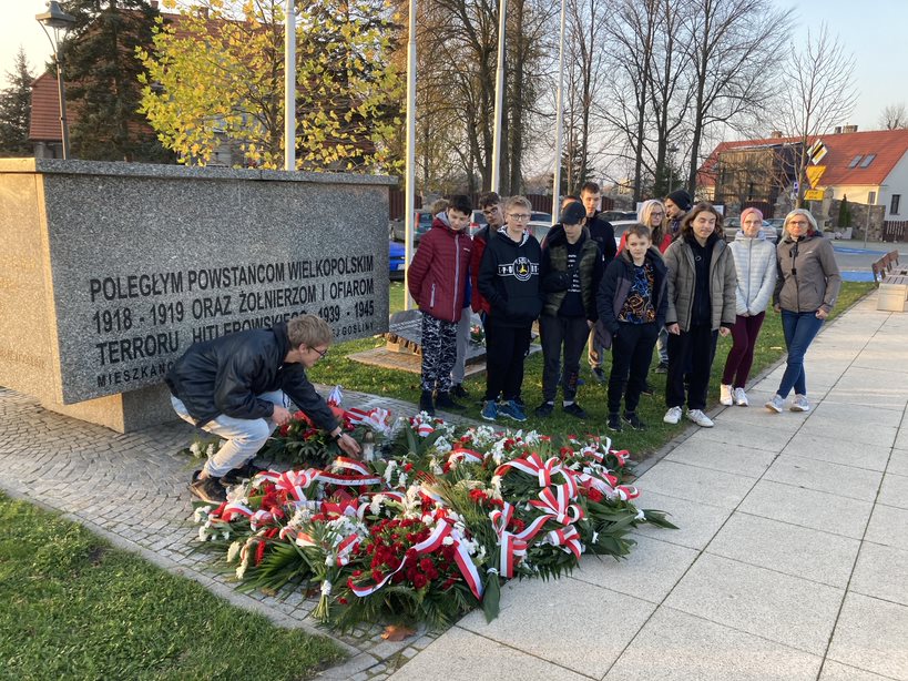 Damian kładzie znicz pod Pomnikiem Poległych Powstańców Wielkopolskich, Żołnierzy i Ofiar Terroru Hitlerowskiego w Murowanej Goślinie