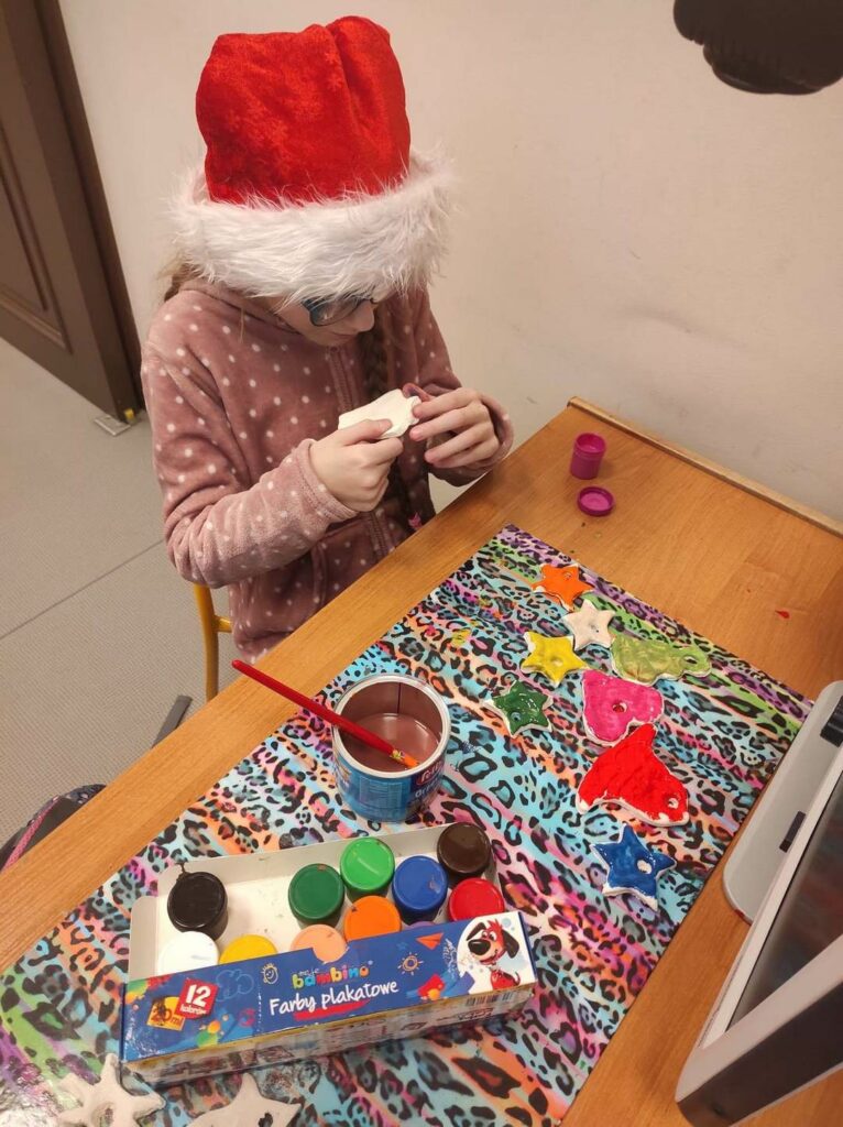 Uczennica z klasy 4a pracuje przy tworzeniu elementów do szopki bożonarodzeniowej przy użyciu farb plakatowych.