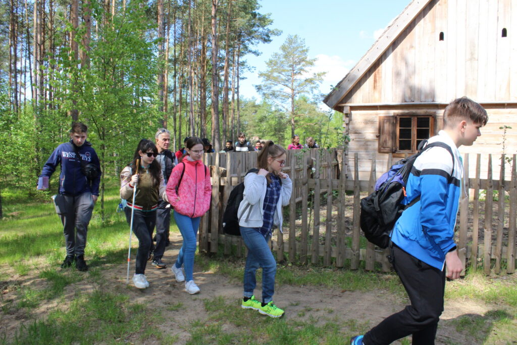 Uczestnicy wycieczki podczas zwiedzania budynków w Kaszubskim Parku Etnograficznym we Wdzydzach Kiszewskich