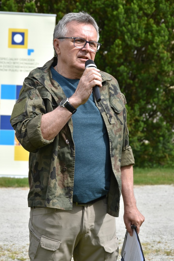 Pan Kierownik Dariusz Jurga z mikrofonem podczas przemówienia na rozpoczęciu pikniku.