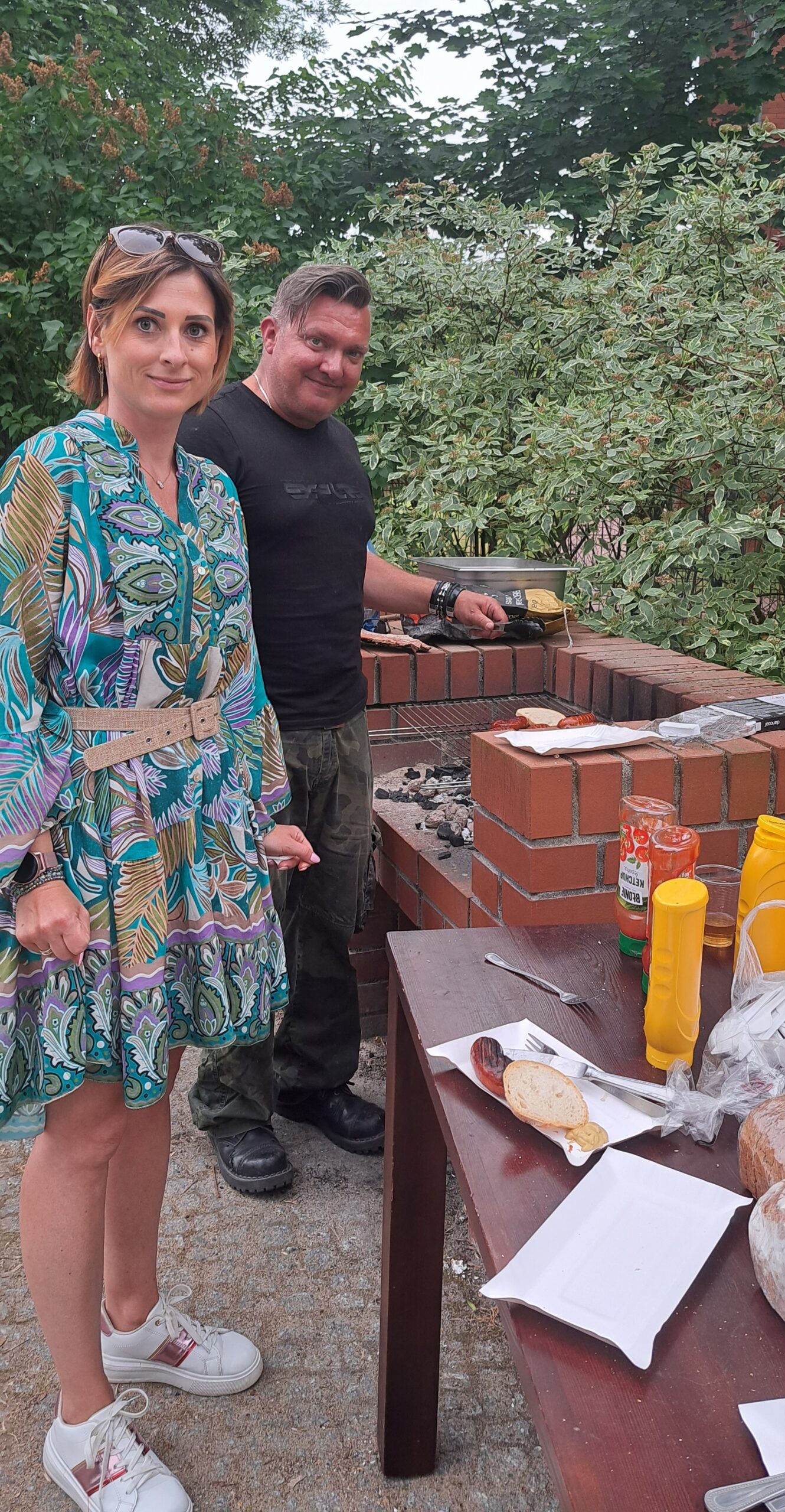 Pan Krzysiu i Pani Karolina przygotowują pyszne kiełbaski z grilla.