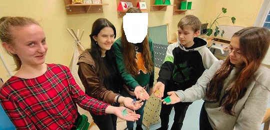 Wiktoria, Katia, Andrzej i Jagoda prezentują na wyciągniętej dłoni bryły wykonane z żywicy epoksydowej.