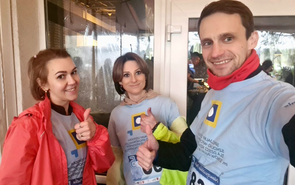 Od lewej pani Agata, pani Karolina i Pan Marcin w koszulkach z logo Ośrodka pozują z kciukami w górze.